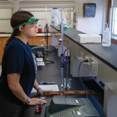 Two women in a chemistry lab conducting experiments and analyzing data.